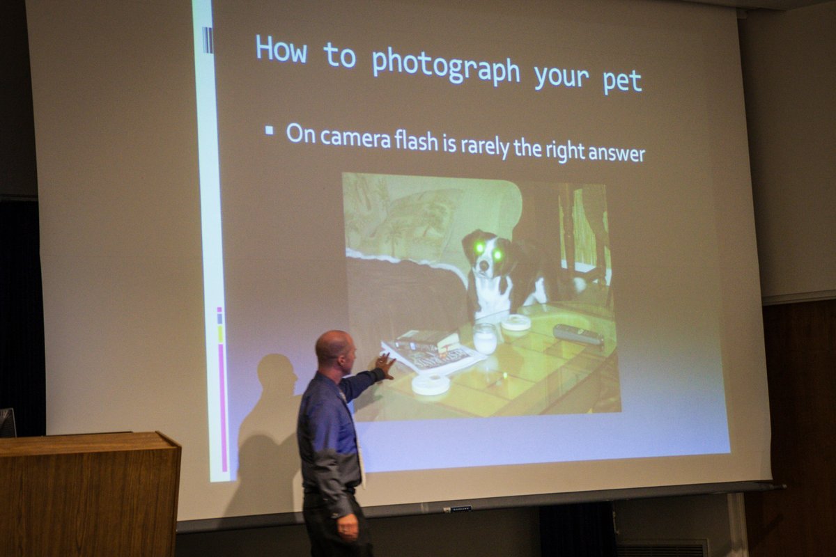 Michael Kloth presenting a pet photography talk at Washington State University Tri-Cities, gesturing at a projected slide reading How to photograph your pet